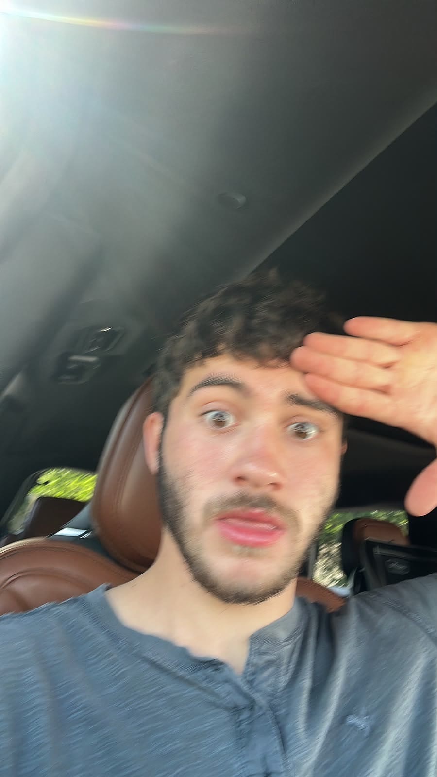 Sruly saluting in a car looking alarmed